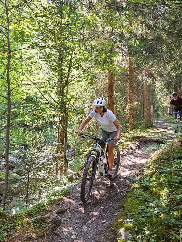 Mit dem Mountainbike auf einem Waldwege entlang fahren